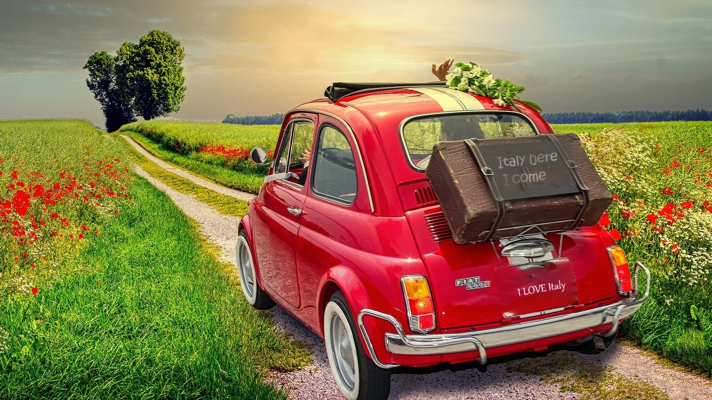 Vintage Fiat 500 surrounded by colorful flowers, creating a charming and nostalgic scene. Italian old school